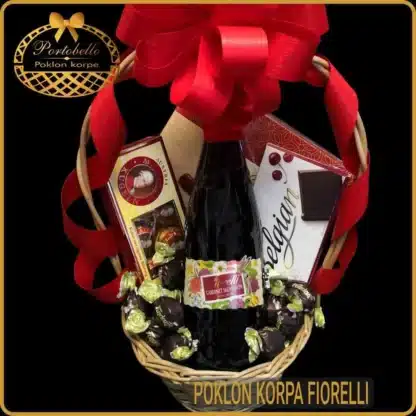 Poklon korpa Fiorelli sa crvenim vinom, čokoladama i pralina bombonjerom u pletenoj korpi sa crvenom mašnom