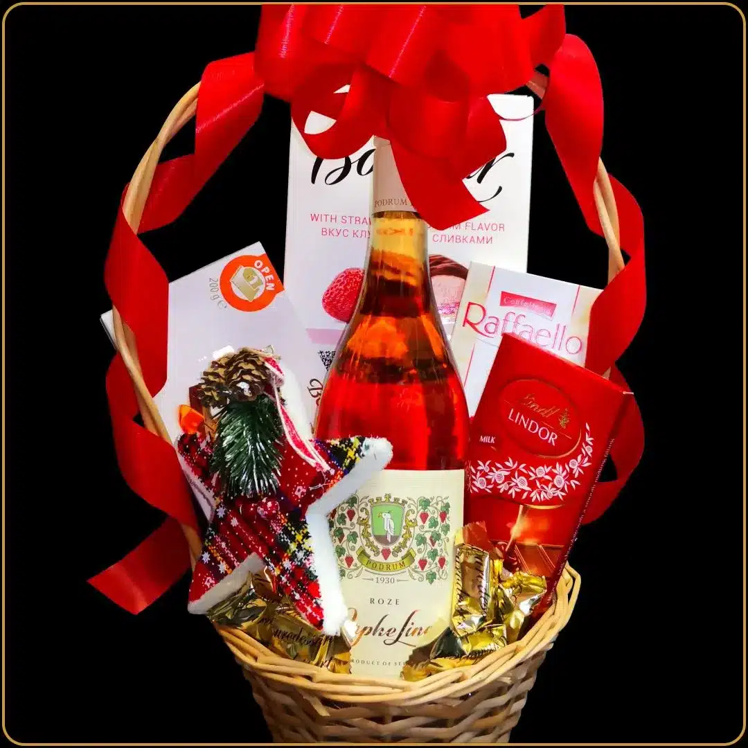 novogodišnji poklon orfelin rose sa vinom i čokoladama u pletenoj korpi