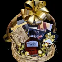 Poklon korpa Gentleman Jack sa viskijem od 0,7 l, čokoladnim poslasticama i zlatnom mašnom u pletenoj korpi